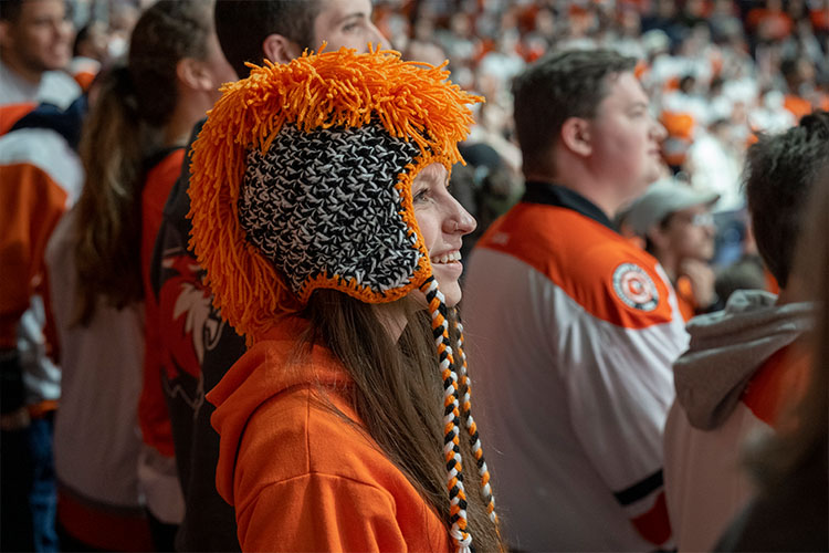 A student wears R-I-T gear at a hockey game during FreezeFest