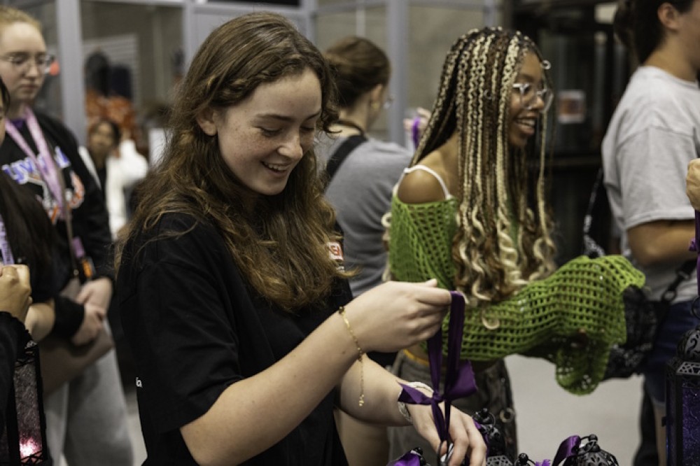 Two students have fun tying bows at the Lighting the Way event.