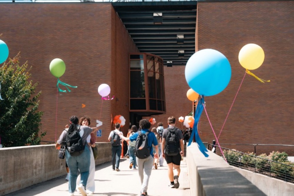 Students walk along the quarter-mile during RIT’s Tiger Takeoff, celebrating the start of the semester with a festive campus atmosphere.