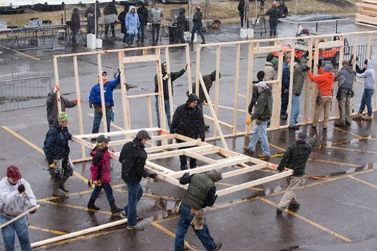 volunteers building framing for a house.