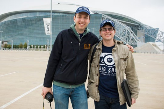 People posing outside of stadium