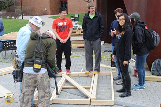 volunteers building framing for a house.
