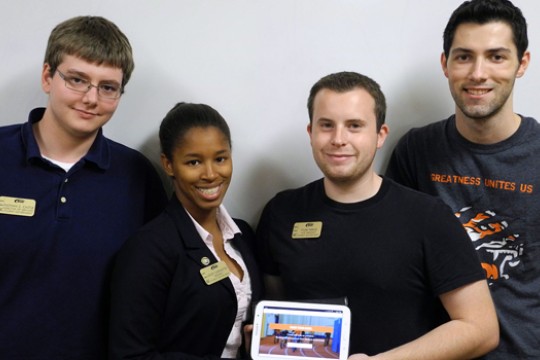 Four people posing with tablet
