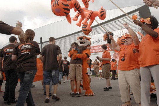 Person hugging tiger mascot in crowd