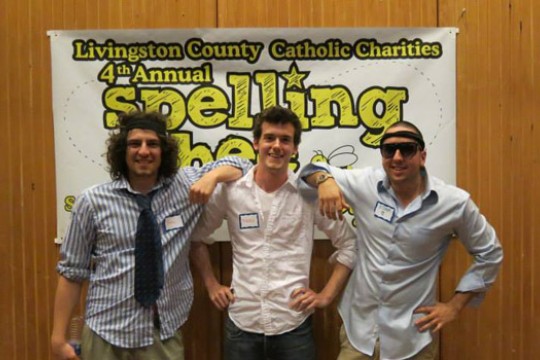 People posing in front of sign