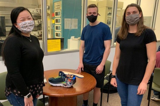 three students with their sneaker project.