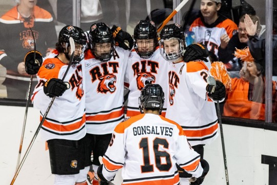 the RIT Mens hockey team is shown celebrating after a team win.