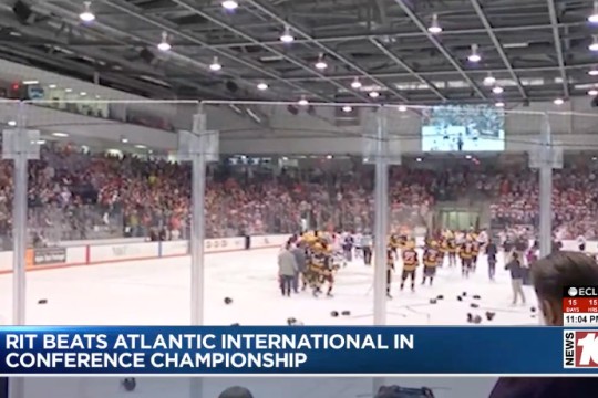 The RIT mens hockey team is seen celebrating on the ice after winning their championship.
