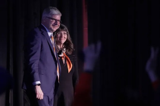 William Sanders appears next to his wife, Emily, on a stage at RIT.