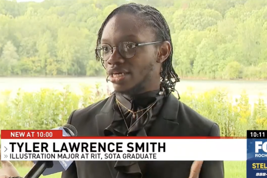 a young man stands in a park like area speaking to a T V reporter.