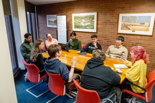 Members of the Interfaith Council meet in a small conference room around a table.