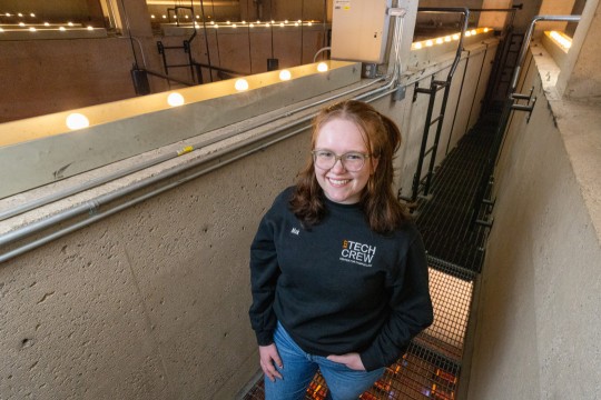 a girl stands in a cement stairwell