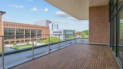 left side view of a terrace space with a wooden floor and railings.