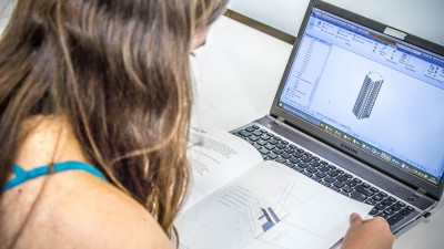 Architecture student designs model on computer.