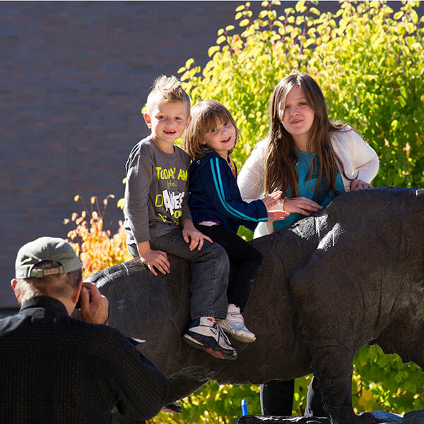 A family taking a picture on the RIT Tiger Statue