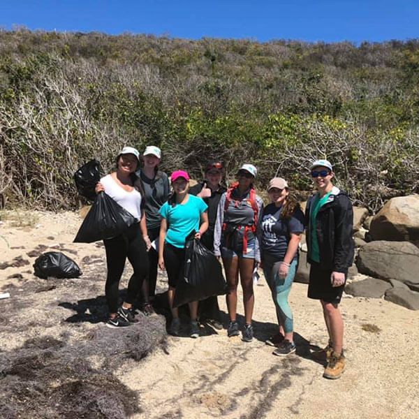 A group of students posing for a photo during an outdoor activity at Alternative Spring Break