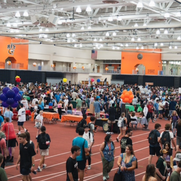 A wide shot of students checking out various booths during TigerFest at RIT
