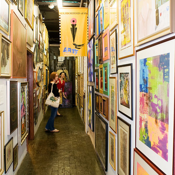Interior view of Artisan Works showing a hallway filled with paintings and photographs