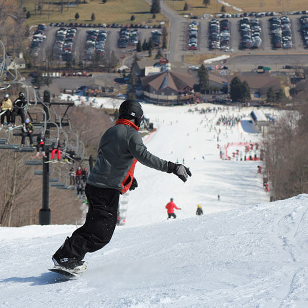 An RIT student snowboarding at Bristol Mountain