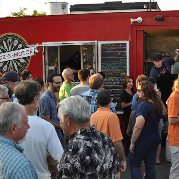 People lined up outside of a food truck
