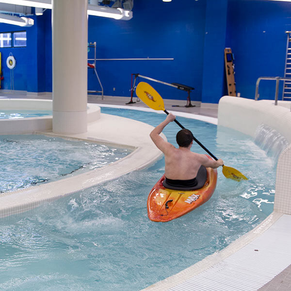 An RIT student kayaking in the lazy river in the Judson/Hale Aquatics Center