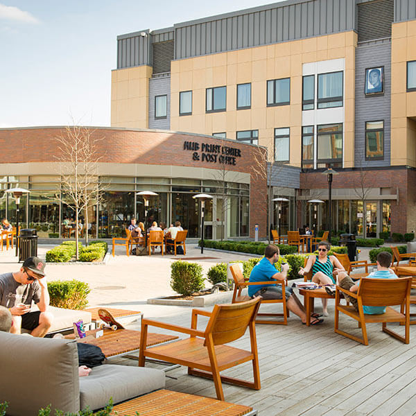 RIT Students sitting on chairs and couches in Global Village