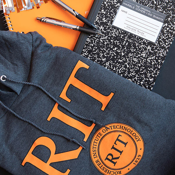 An RIT hoodie, a notebook, and a couple of pens