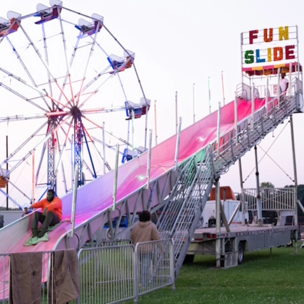 A photo of a fun slide and ferris wheel during CAB carnival at FallFest