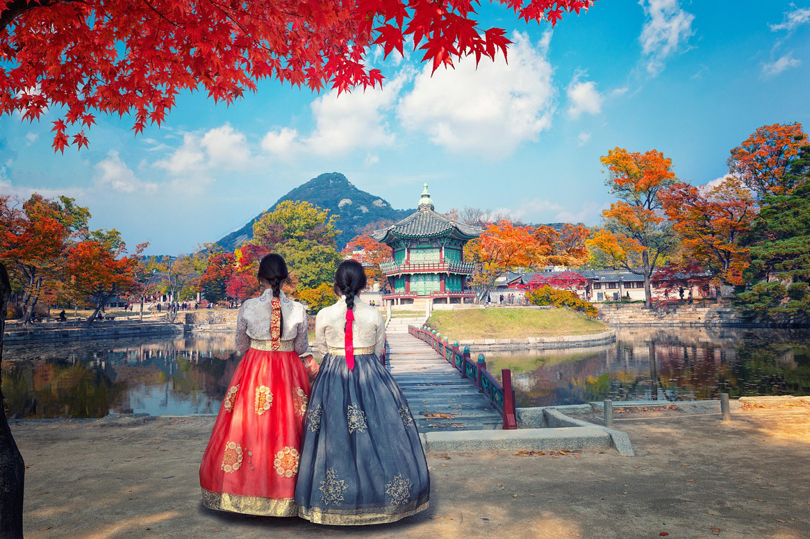 Two women in traditional South Korean clothing with mountain in distance