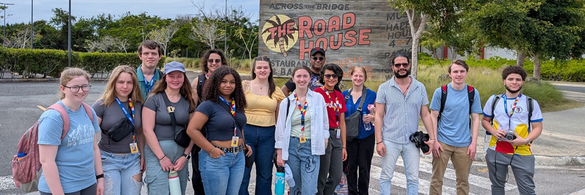 Group of RIT students standing in front of a restaurant sign in the Dominican Republic