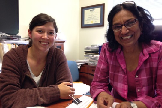 Two people posing at a desk