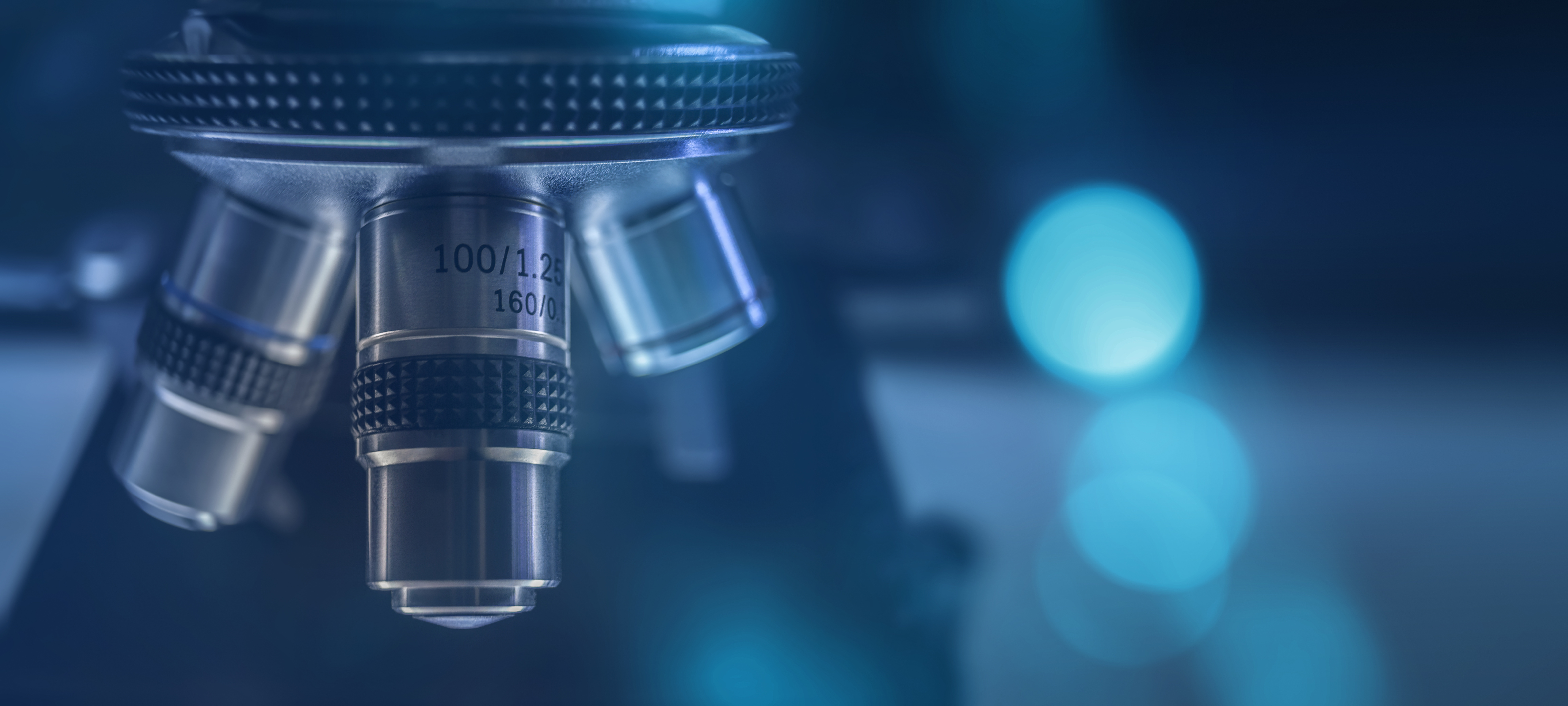 dark blue image of close up of three pronged microscope with blurry background