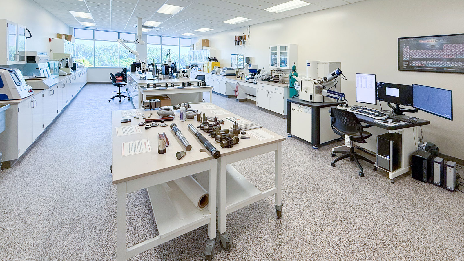 a lab setting with several tables with different kinds of equipment, including computers, and high tech scales and scanners.