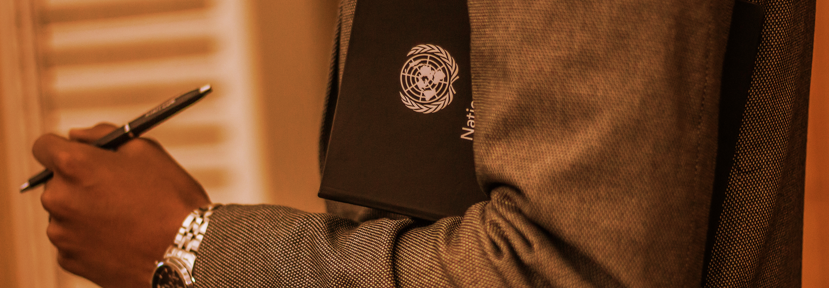 Person wearing a suit holding United Nations folder