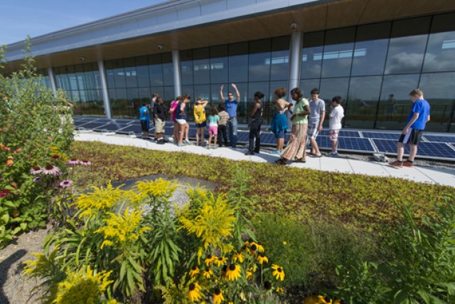 People looking at solar panels on a roof