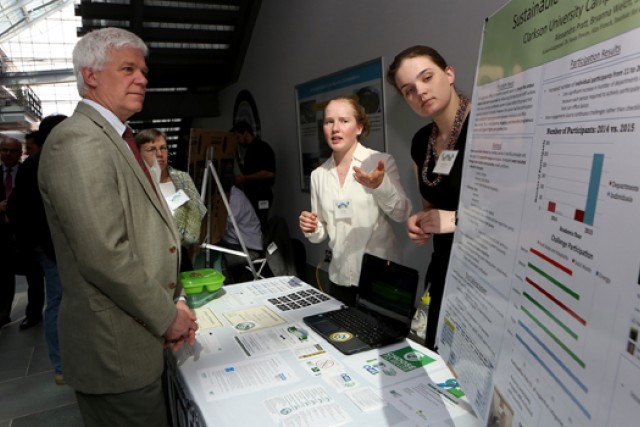 Students showing poster to reviewers