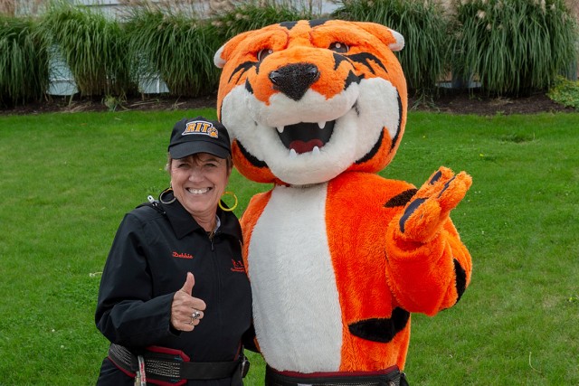 woman posing with tiger mascot.