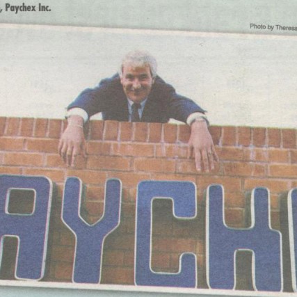 A newspaper clipping of a 1988 issue of the Rochester Business Journal featuring Tom Golisano and the Paychex sign. 