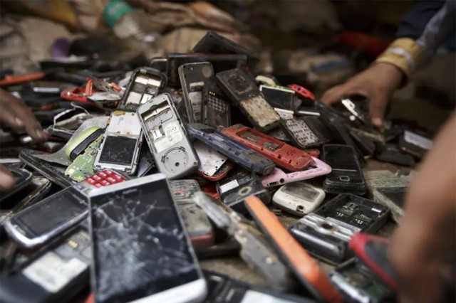 a pile of old and broken cellphones. 