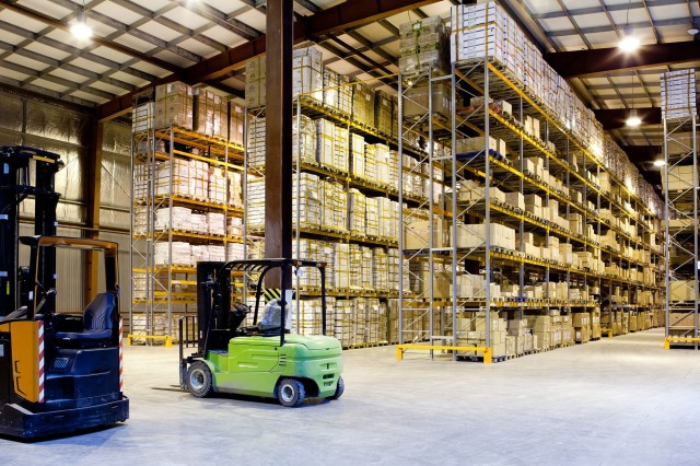 Forklifts are parked in a large warehouse facility. 