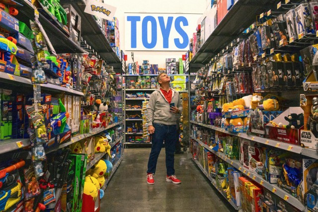 a man looking through in a toy aisle at Walmart.
