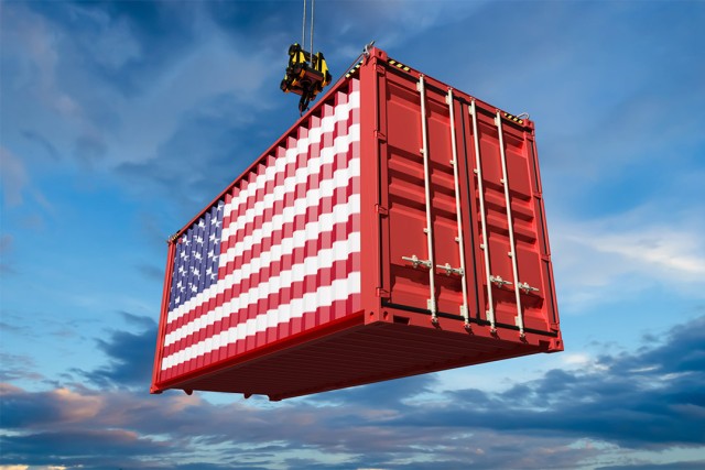 a shipping container painted to look like the american flag is hanging by a crane.