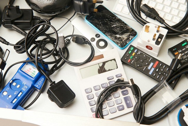 a drawer full of old handheld electronics and cords.
