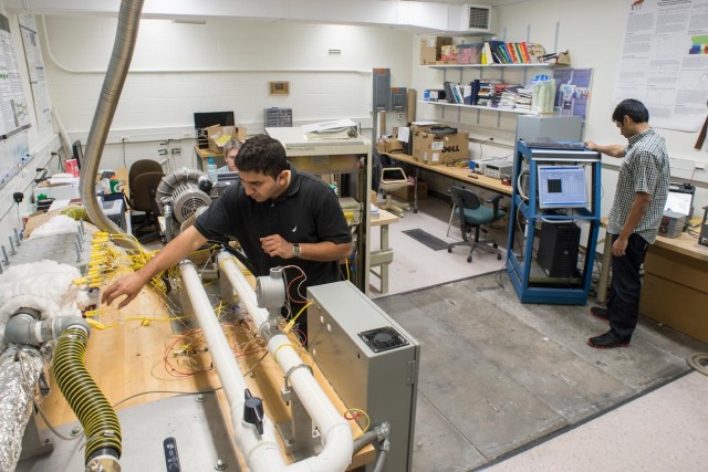 Workers calibrating a machine before running a test