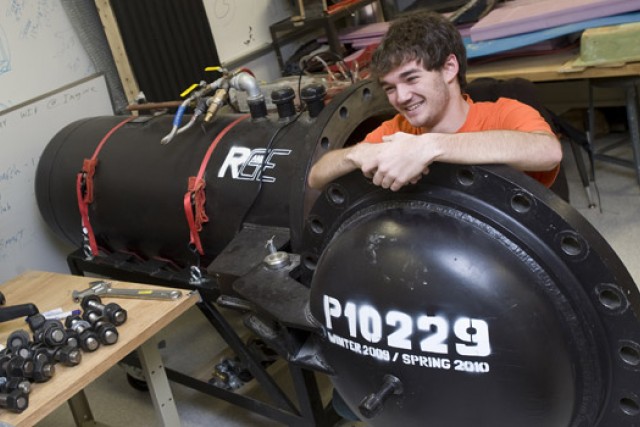 Picture of student next to project