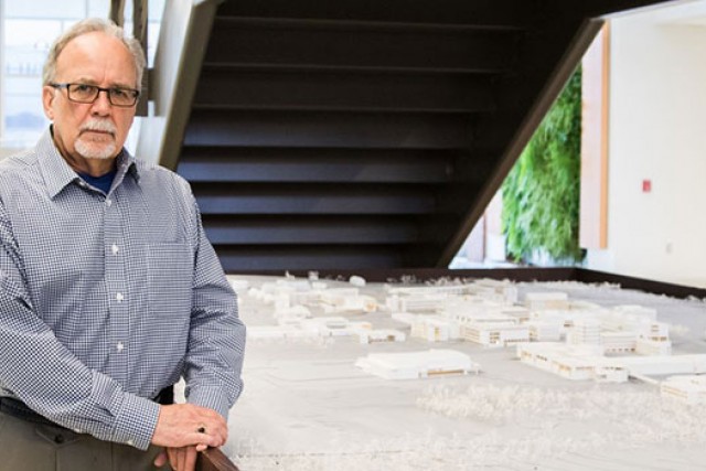 Dennis A. Andrejko poses next to architecture work.