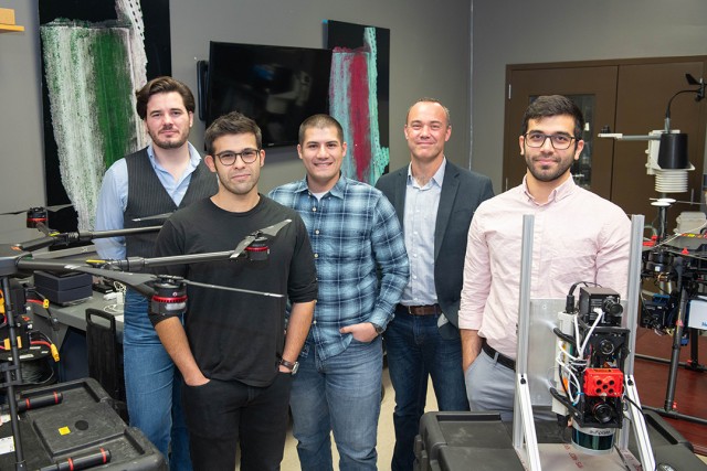 Professor and students stand with drone.
