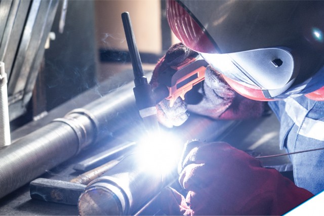 Man welding metal pipe