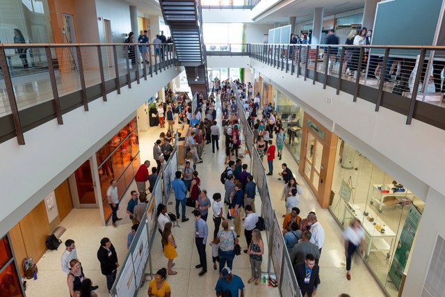 Overhead view of crowd of people in building lobby.