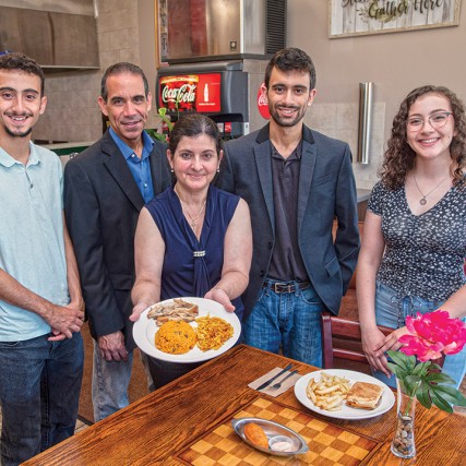 family of five standing in a restaurant.
